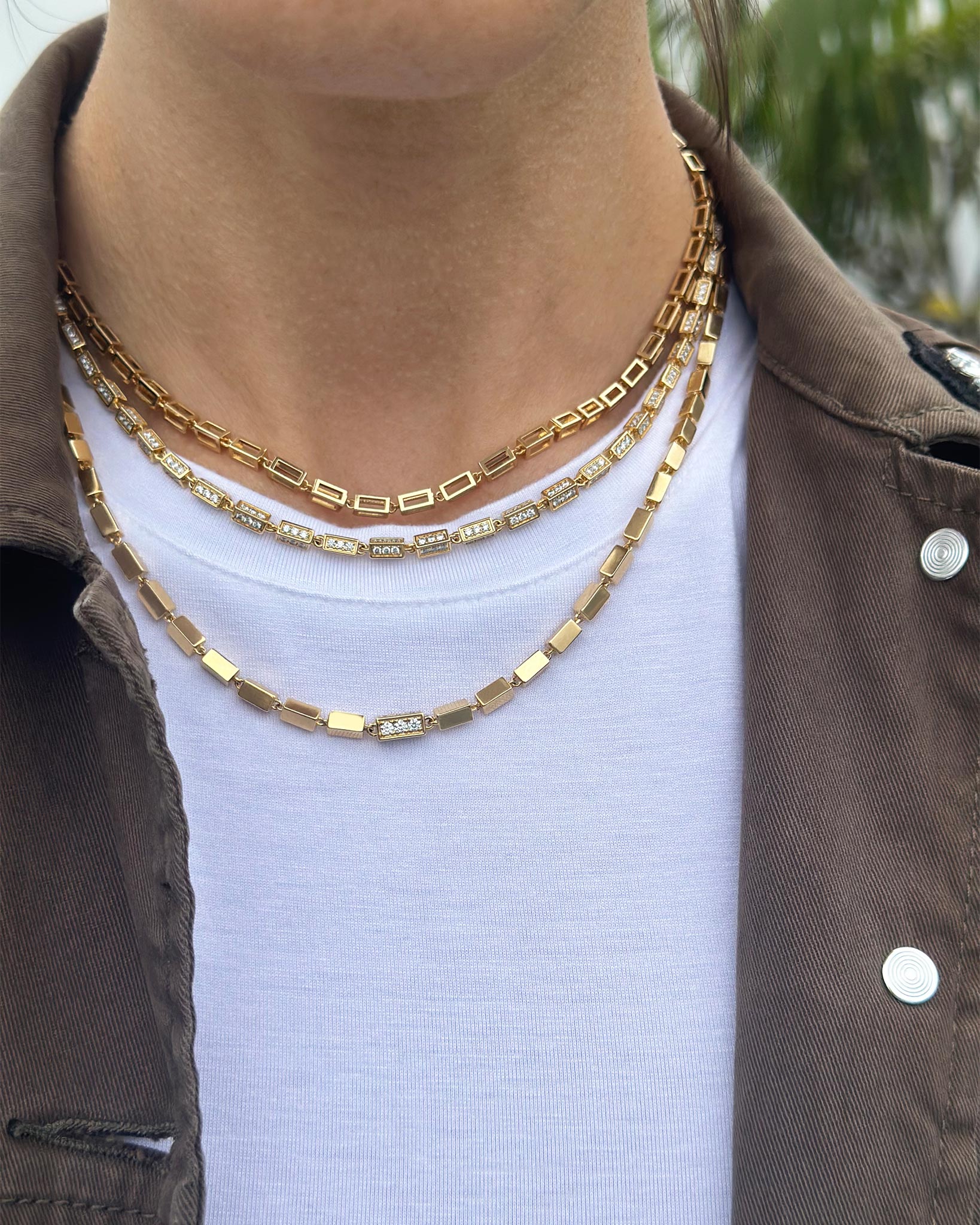Suzanne Kalan model styling three Block-Chain necklaces in 18k yellow gold